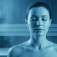 closeup person in sauna in light blue with dark blue background: sauna, sweating, detox, health