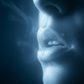Light with black background, light is light blue, black is dark blue: close-up mouth doing breathing exercises