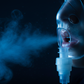 Light with black background, light is light blue, black is dark blue: close-up mouth with nebulizer