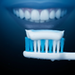 Light with black background, light is light blue, black is dark blue. close-up of mouth with beautiful smile next to toothbrush with toothpaste