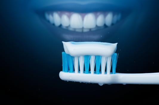 Light with black background, light is light blue, black is dark blue. close-up of mouth with beautiful smile next to toothbrush with toothpaste