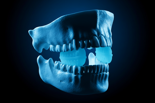 Light with black background. light is light blue, black is dark blue. photo of an upper and lower jawbone with a  jaw exerciser training jaws